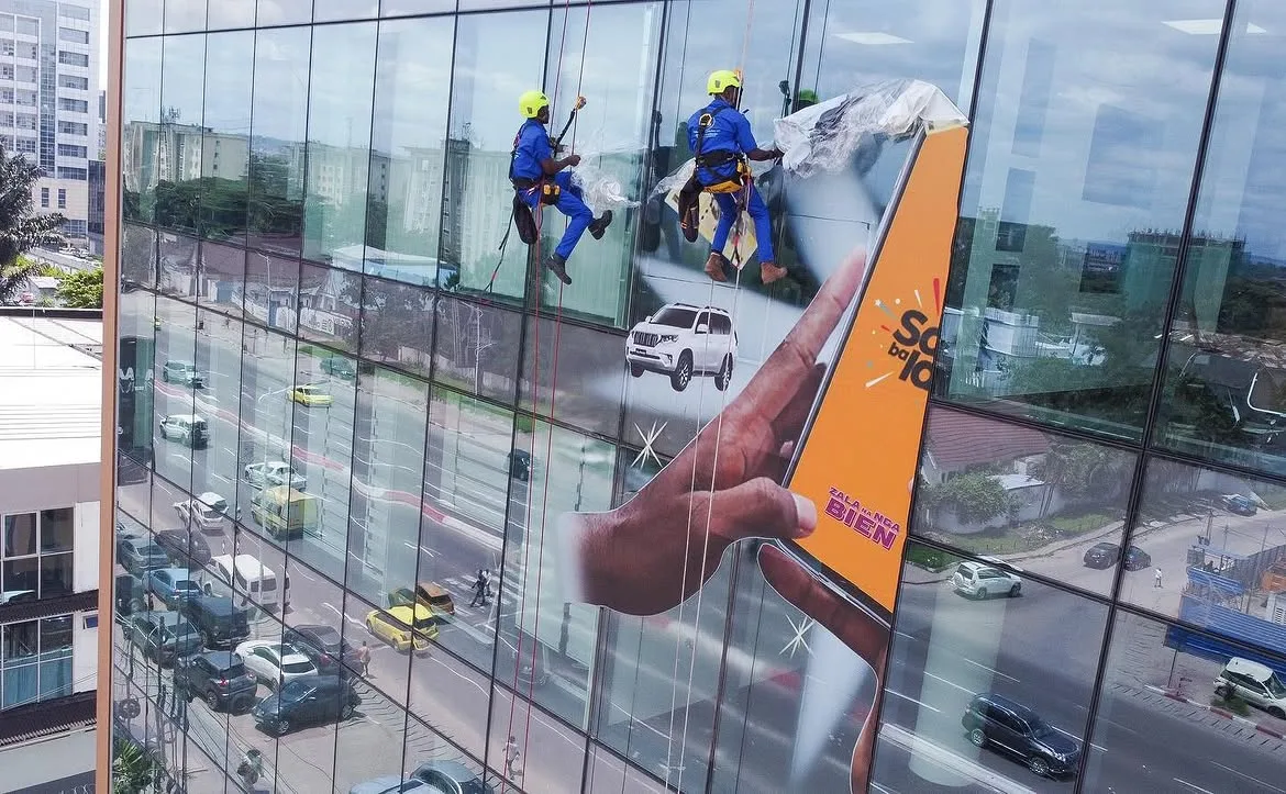 Cordistes BAM'S CLEAN nettoyant la façade vitrée d'un immeuble de bureaux à Kinshasa